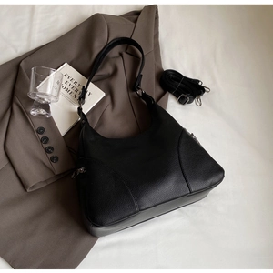 Detail of black lychee grain leather hobo bag with adjustable shoulder strap and gunmetal hardware