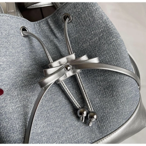 Macro detail of metallic silver bucket bag with glitter texture and decorative bow accent