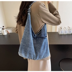 Detail of vintage blue denim tote bag showing silver metal buckle and side button pocket