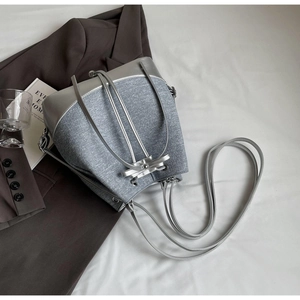 Detailed top view of a silver bucket bag with contrasting textures on a stylish setting