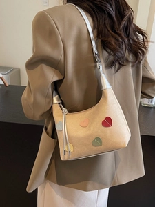 Beige canvas shoulder bag with colorful heart patches and silver metal accents