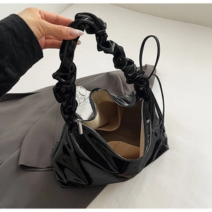 Detailansicht der schwarzen Lackleder-Tasche mit modischem, gerafftem Scrunchie-Griff