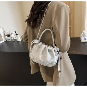 Detail of light gray pleated cloud bag with silver heart buckle and pearl handle decoration