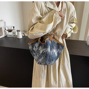 Detail der blauen Jeans-Einkaufstasche mit silbernen Pailletten und braunem Leder