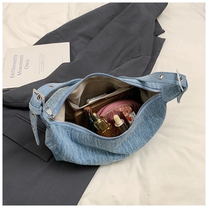 Internal view of blue denim shoulder bag showing spacious storage and zipper pocket