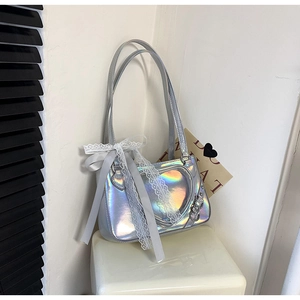 Detail of silver laser heart crossbody bag with decorative ribbon and lace bow