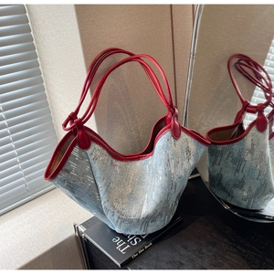 Nahaufnahme der Jeans-Tasche mit silbernen Pailletten und roten Leder-Henkeln