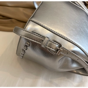 Detail shot of silver metallic chain bag showing textured faux leather and metal buckle