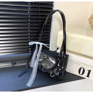 Detail of black patent leather ita bag with heart window and white lace decoration