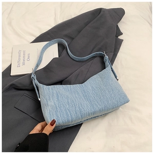 Detailed close-up of light blue denim hobo bag texture and silver metal buckle