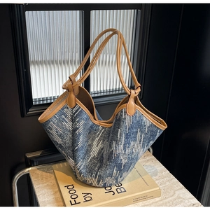 Detail der blauen Denim-Tragetasche mit silbernen Pailletten, Wellenmuster und Ledergriffen