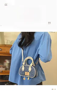 Dettaglio di una mini borsa Boston in denim con manici in pelle crema e tracolla