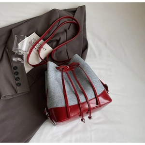 Detail of red leather and grey felt bucket bag with silver drawstring beads and strap