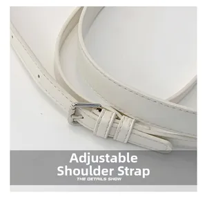 Close-up of adjustable white leather shoulder strap with polished silver metal buckle