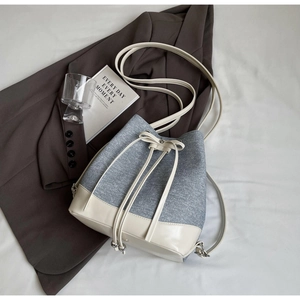 Detailed overhead shot of a blue and beige contrast bucket bag with drawstring closure