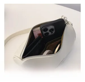 Interior view of white cylinder bag showing spacious storage for phone and cosmetics