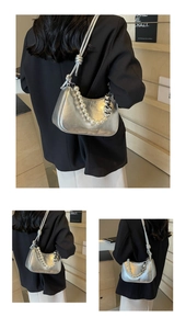 Detail of silver metallic baguette bag featuring pearl handle and heart-shaped chain
