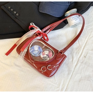 Detail of red patent leather ita bag featuring a heart-shaped window and lace trim