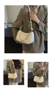 Detail of cream white underarm bag with pearl and silver heart-shaped metal chain strap