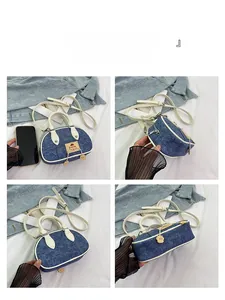 Dettaglio mini borsa a tracolla in denim a contrasto con tessuto blu e finiture bianche