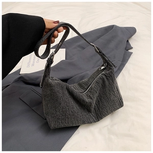 Detail of grey denim crescent shoulder bag with adjustable strap and silver hardware
