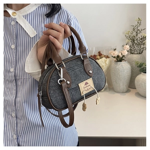 Dettaglio della mini borsa a bauletto in denim con patch fashion e manici in cuoio