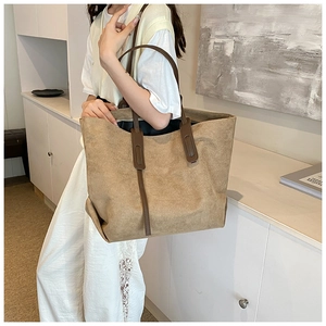 Large khaki tote bag with brown leather handles showing spacious capacity for commute