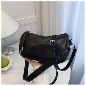 Detail of black cylindrical boston bag with silver hardware and leather texture