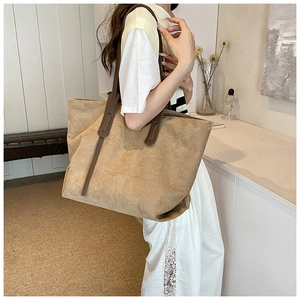 Detail of khaki suede tote bag with brown leather shoulder straps for daily commuting use