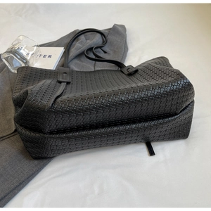 Detail shot of the black woven tote bag showing premium texture and large capacity design