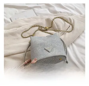 Detail of marble pattern bucket bag with metal chain strap and protective base feet
