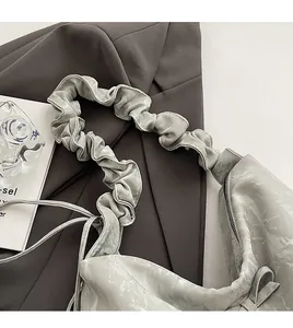 Détail du sac à bandoulière plissé gris avec cuir souple et large sangle confortable