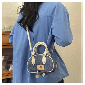 Vista posteriore modella con mini borsa a tracolla in denim e finiture in pelle