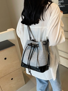 Large capacity contrast drawstring bucket bag shown on model in modern casual setting