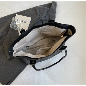 Top view of large woven tote bag interior with beige lining and zipper pocket