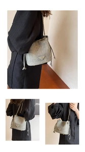 Close-up of grey drawstring bucket bag with marble texture and golden chain strap