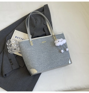 Detail of grey tote bag with silver leather trim and a cute plush cloud pendant