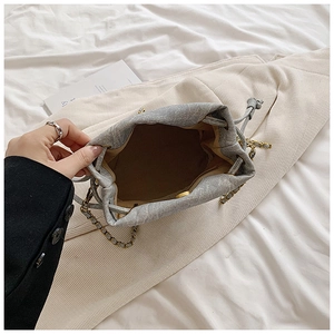 Top view of grey denim drawstring bucket bag showing interior lining and magnetic closure