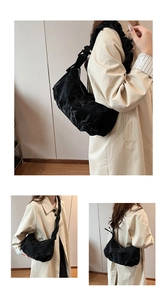 Détail du sac à bandoulière croissant noir matelassé avec texture en nylon plissé