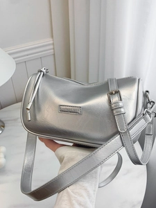 Silver metallic cylinder shoulder bag with adjustable strap and branding detail