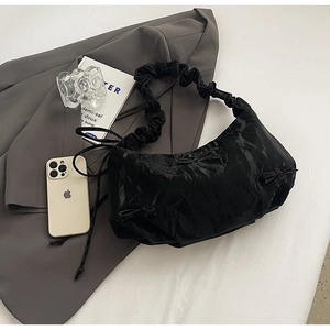 Détail du sac à bandoulière plissé noir avec mini nœuds et bandoulière à volants