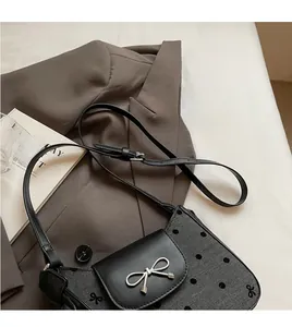 Nahaufnahme der silbernen Schleifenschnalle und des gepunkteten Stoffes der Handtasche