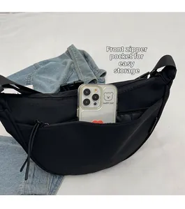 Detailed view of large capacity black nylon crossbody bag with front zipper pocket