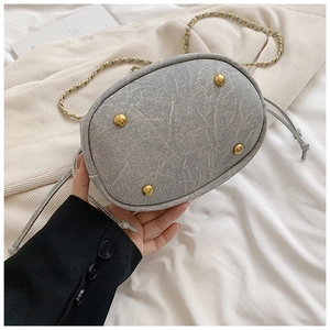 Detailed view of the drawstring bucket bag base with protective gold metal feet