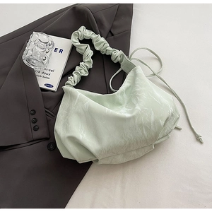 Détail du sac plissé vert menthe avec un tissu doux à texture marbrée élégante