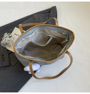 Top view of large denim tote bag interior with zipper pocket and leather handles