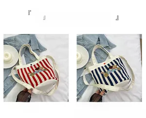 Détail de sacs seaux en toile avec motifs rayés et broderie de chiot mignonne