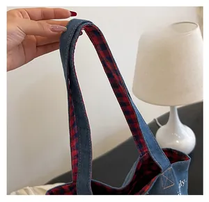 Dettaglio della tracolla in denim che mostra cuciture di alta qualità e comfort d'uso