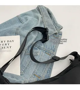 Detail view of adjustable shoulder strap and durable buckle on black canvas bag