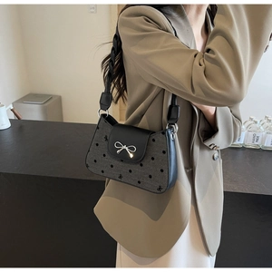 Detail der grauen Schleifen-Stofftasche mit silbernem Schleifenverschluss am Flap